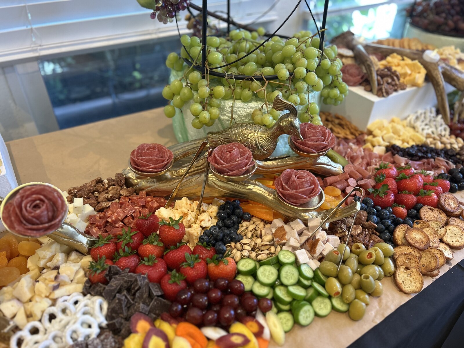 Grazing table spread with salami roses, strawberries, olives, cheeses and crostini