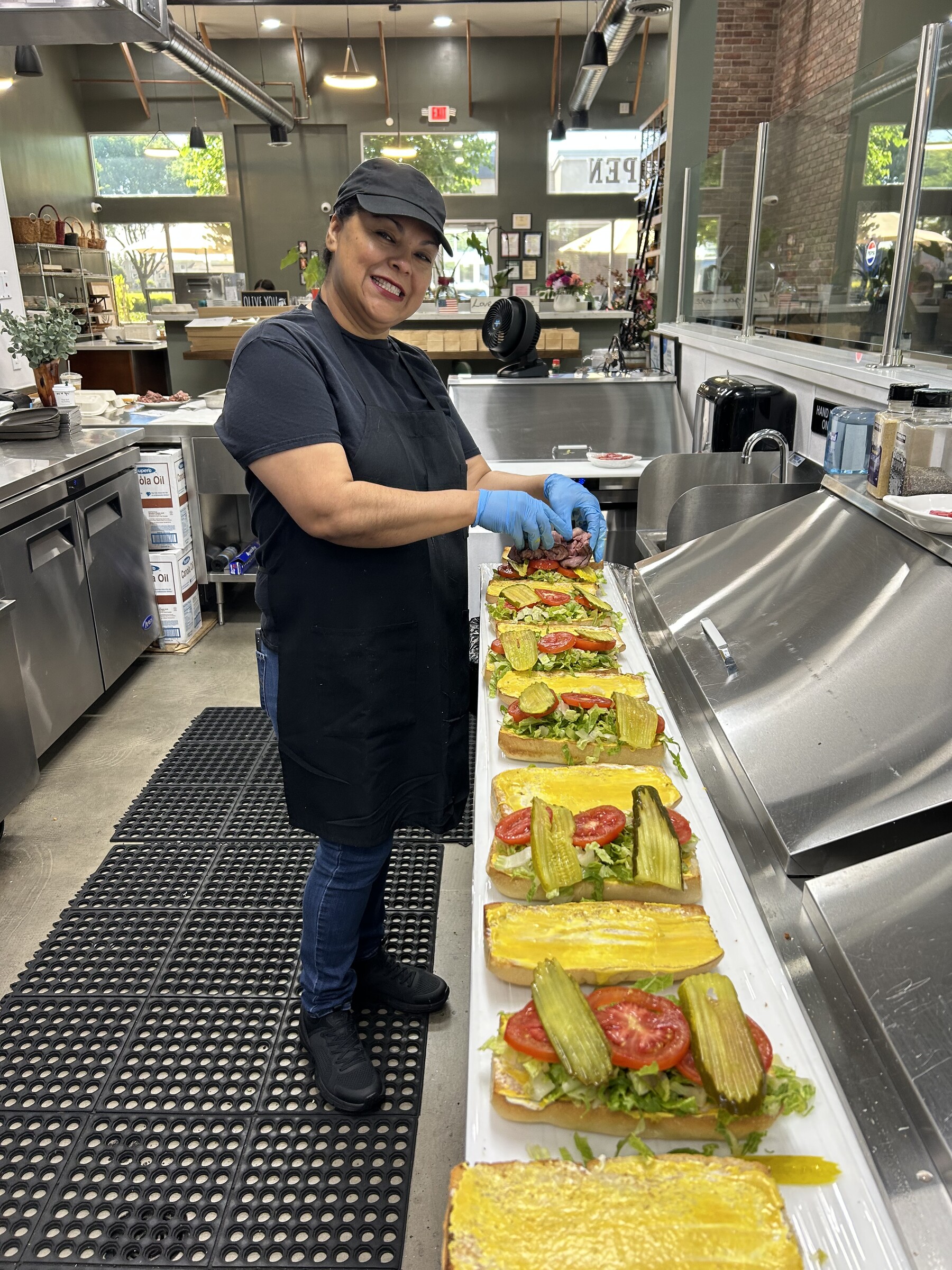 CharQterie team member preparing fresh gourmet sandwiches in the open kitchen